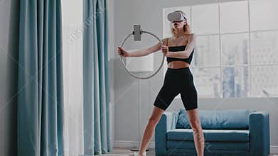 Woman trains with VR headset holding ring with fixed phone
