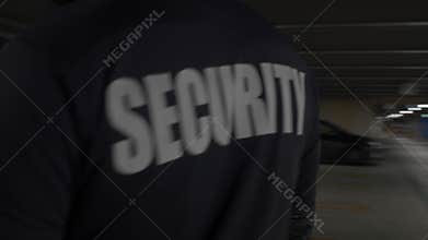 Security guard in uniform patrolling commercial area.