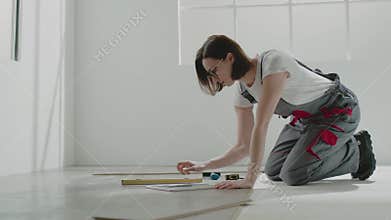 Woman apartment owner writes down floor level measurements