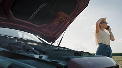 Handheld video of helpless woman calling roadside assistance.