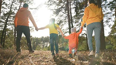 people in the park. happy family silhouette walk at sunset. mom dad and son walk holding hands in the park. happy family