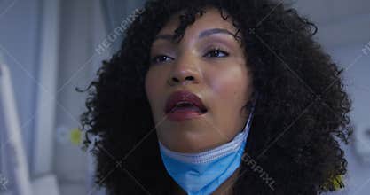 Female mixed race patient wearing protective clothes having covid swab test