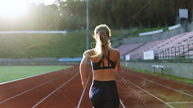 Rear view of athlete Woman Running Fast at Track in the Morning Light , Training Hard, Getting Ready for Race