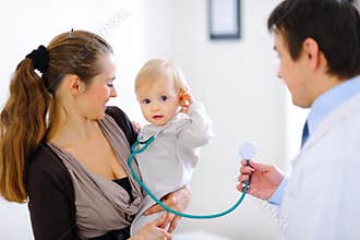Baby on mamas hand playing with stethoscope