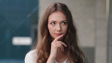 Woman portrait outdoors caucasian millennial beautiful pensive girl puzzled embarrassed woman model female student