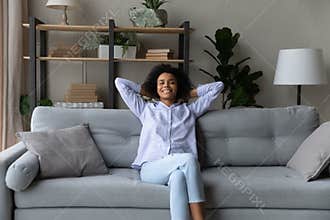 Tranquil teenage black female chill on comfy couch at home