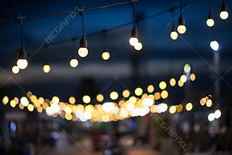 Hanging light bulbs with blur outdoor shopping mall