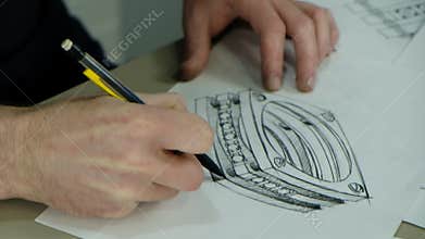 Craft goldsmith work. Portrait of young jeweler drawing a sketch of a new ring. Concept of: wedding, luxury, jewelry