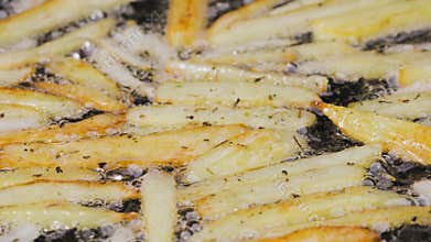 Golden crispy wedges of potatoes are fried in oil in a hot skillet in the kitchen. The process of cooking a potato dish