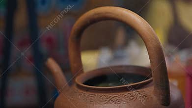 Clay teapot with ornament steaming with aromas of herbs
