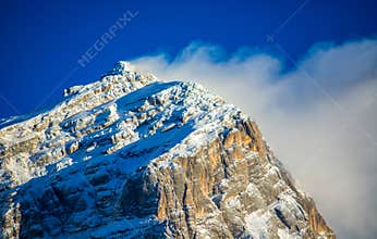 a strong wind blows on the top of the mountain whitened by the first snow of autumn