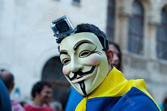 Man wearing an Anonymous mask protesting