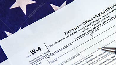 U.S. Employee\'s Withholding Certificate Form W-4 with Pen and American Flag Background