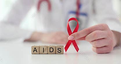 Red ribbon and wooden cubes for spelling AIDS and doctor
