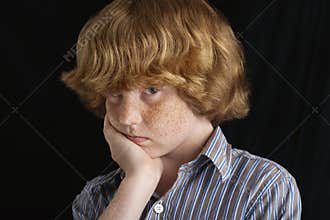 Upset Boy With Hand On Chin
