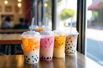 Four boba tea drinks standing on a table in a cafe