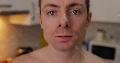 A man eating cashew nuts at kitchen