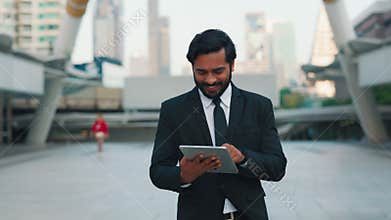 Satisfied man walking with tablet and looking at screen