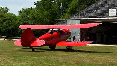Red biplane taxi's down runway