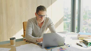 A professional entrepreneur works focused on tasks in a modern office setting. Bright workspace with a busy atmosphere