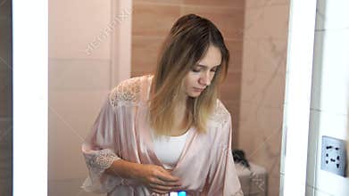 Cosmetics, morning and woman spraying perfume in bathroom with towel, smile and luxury product. Getting ready, care and