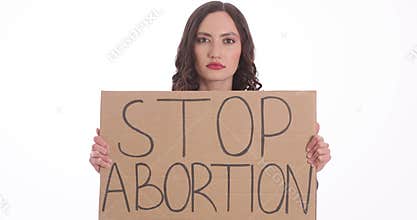 Serious woman shows sign Stop Abortion on white background