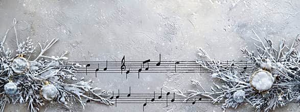 Musical staff border on light gray background with snow garlands