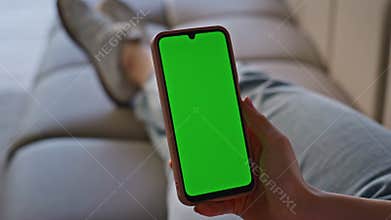 User hand swiping chromakey smartphone lying sofa closeup. Woman scrolling phone