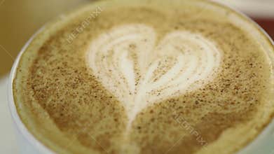 Adding sugar to cup of coffee.