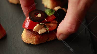 Preparing Caprese Crostini Party Appetizer Food on Dark Stone Plate CloseUp