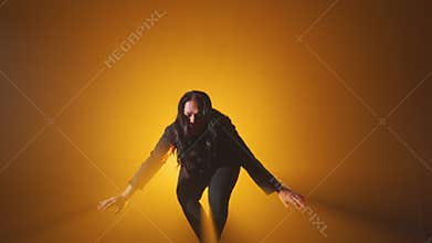 Dramatic Crouching Pose Against Yellow Background