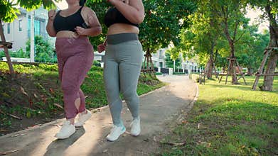 Two asian woman fat in sportswear jogging together on pathway at park, woman and friends obesity doing activity with cardio.