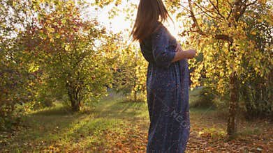 Beautiful pregnant woman having walk in the park