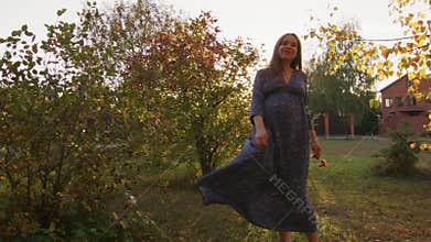 Beautiful pregnant woman having walk in the park