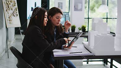 Real estate agency employees designing building blueprints