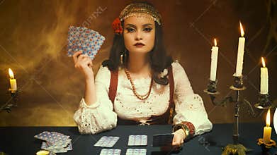 fantasy girl in image of gypsy witch. dark gothic room. Art dress red costume.