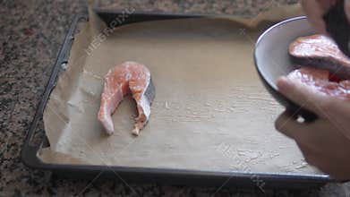 A person is holding a bowl of food over a pan