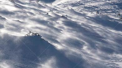 Strong wind blowing snow in frozen winter alps mountains in windy nature, wind warning outdoor background