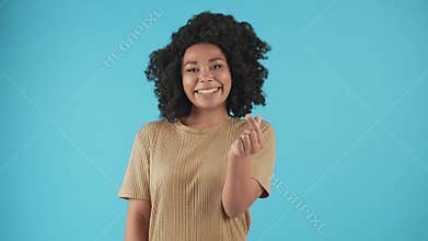 Smiling black girl showing korean love sign. Happy African American woman making heart gesture