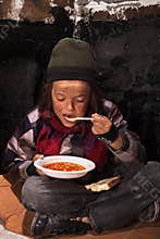 Poor beggar child eating charity food