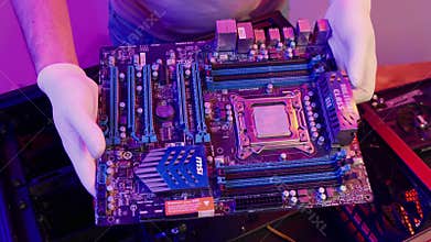 PC technician serves Modern motherboard close up. Upgrading computer mainboard