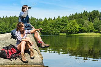 Teenage hikers birdwatching at lake