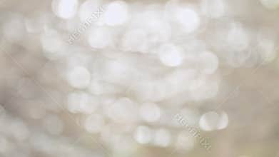 Bokeh gold color particles flow and light flare. Sun reflects and sparkles on waves with bokeh lights. Out of focus.