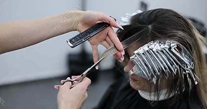 Hairdresser cuts a client bangs in hair salon