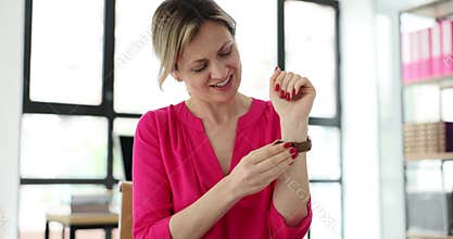 Businesswoman puts on new wristwatch presented by employees
