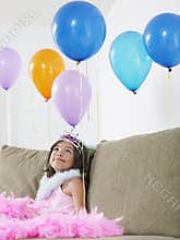 Girl Looking Up At Balloons On Sofa
