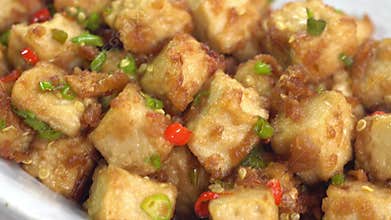 The tofu is coated in soy sauce and sesame oil.