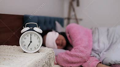 A Asian woman sleeping with an eye mask in a bright room