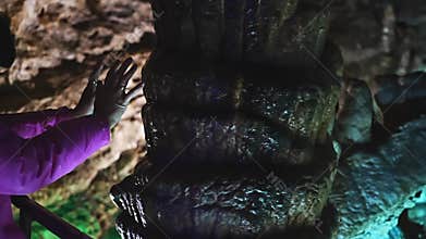 Hands at the stalagmite to make a wish