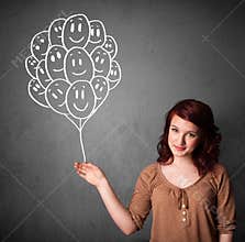 Woman holding a bunch of smiling balloons